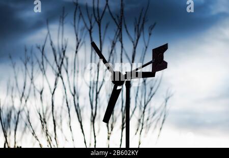 home made wind propellers with tree branches on the foreground Stock Photo