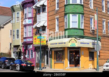 A colorful corner of Germantown with row houses and a corner store at the intersection of Duval St, and Germantown Avenue, Philadelphia, PA. Stock Photo
