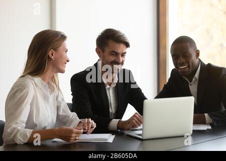 Smiling diverse colleagues having fun during break at office. Stock Photo