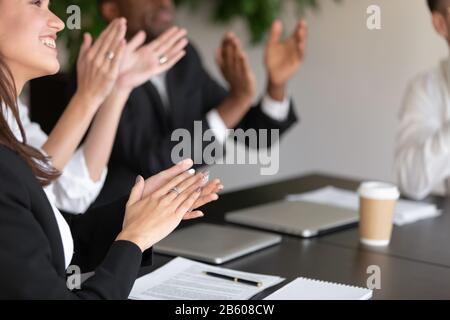 Close up overjoyed female male coworkers applauding. Stock Photo