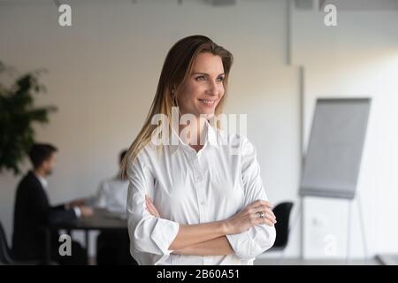 Happy attractive businesswoman standing with folded hands head shot portrait. Stock Photo