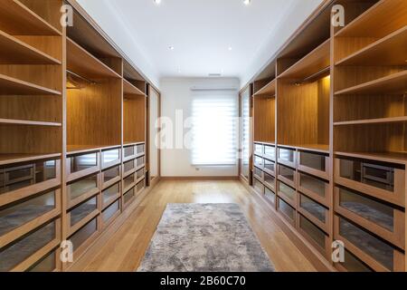 Large wardrobe room, with empty shelves. In house Stock Photo