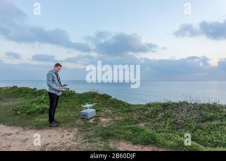 Man is preparing a drone for the flight. For video on the sea. Stock Photo