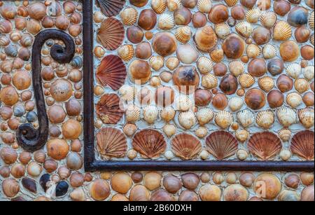 Mosaics made of seashells and a letter from the wall. Close-up. Stock Photo