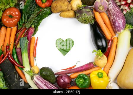 Various vegetables, flat lay frame with green leaf heart love symbol inside. Healthy lifestyle concept. Top view. Stock Photo