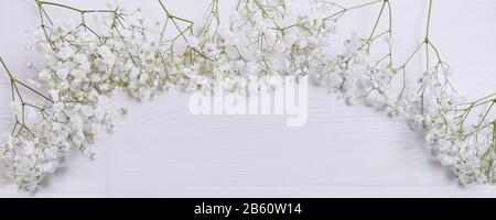 Mock up composition of white flowers gypsophila rustic style, for St. Valentine's Day with a place for your text. Flat lay, top view photo. Panoramic Stock Photo