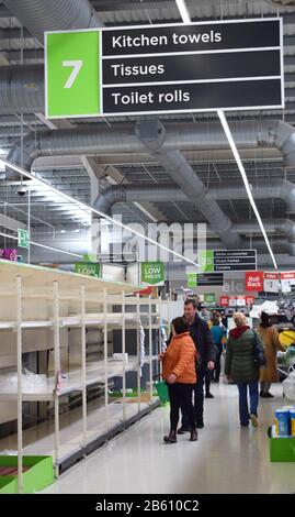 British supermarket shelves in the toilet roll / paper aisle of the store empty as people panic buy and stockpile essentials due to Coronavirus Stock Photo