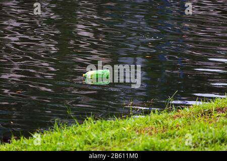A Plastic bottle floating on the clean river, need technology to combat people who dump waster into the water. Stock Photo