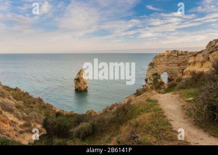 Trail of the Arch on the beach Marinha, Portugal. The waves on the shore.