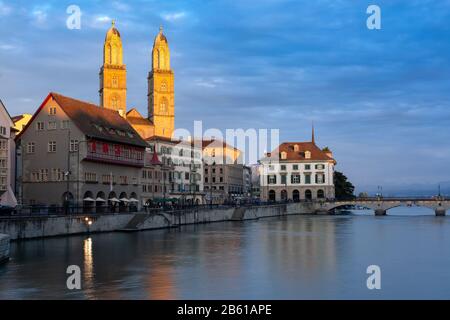 Famous Grossmunster churche along river Limmat at sunset in Old Town of Zurich, the largest city in Switzerland Stock Photo