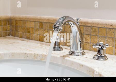 Modern water tap in the bathroom. Flowing water. Stock Photo