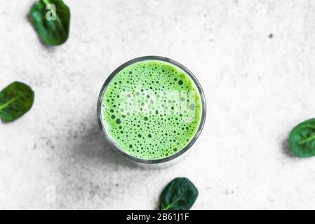 Green Smoothie Drink for healthy vegan detox breakfast, top view, copy space. Fresh spinach smoothie with bubbles close up. Stock Photo