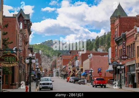 Deadwood, South Dakota, USA - March 2017. The quiet main street of Deadwood set against a mountain backdrop. Stock Photo