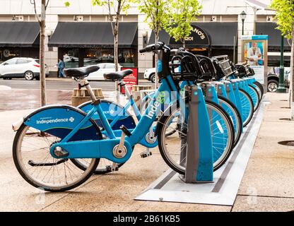 Philadelphia, Pennsylvania, USA - 24 April 2019: Blue Indego bikes locked in a rack ready for customers to bike share in downtown Philadelphia. Stock Photo