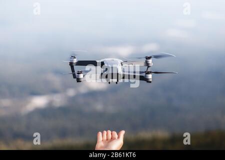 The drone copter for photographer and videographer landing on man hands outdoors Stock Photo