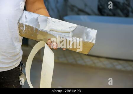 Work hand tool wall using plastering tool for unfinishing wall Stock Photo