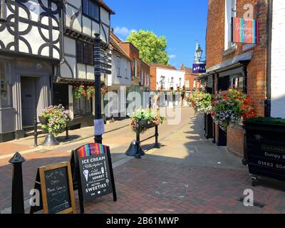 Church Street on a bright and sunny day in the historic town of Godalming, Surrey, England. The town is a popular with commuters who travel to work in Stock Photo