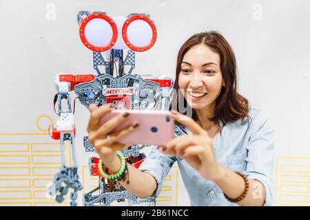 ULTRA MALL, UFA, RUSSIA, 21 AUGUST, 2017: Positive girl making selfies with robot at the exhibition, education concept Stock Photo