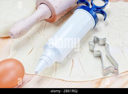 Preparation of sweets for Christmas. Raw dough and tools for cooking. Stock Photo