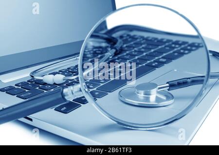 Tools for diagnostics on the laptop. Through a magnifying glass. Stock Photo