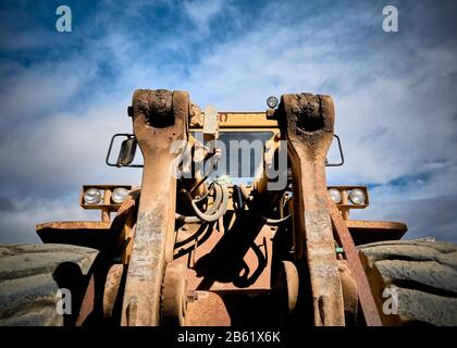 front detail of an old abandoned yellow tractor in a marble quarry Stock Photo