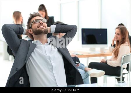 brooding young businessman sitting at an office Desk Stock Photo