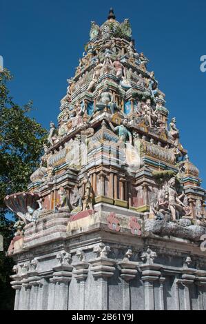 Gopuram top against blue sky background. Gopuram (Gopura (singular)) is a monumental decorated  Hinduism tower. Stock Photo