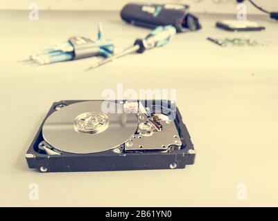 Opened computer hard drive on a table prepared to be fixed. Stock Photo