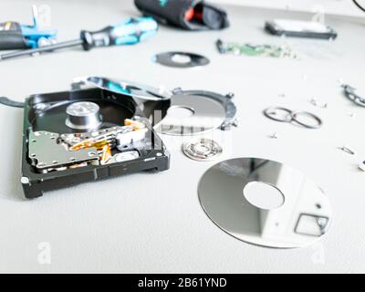 Opened computer hard drive on a table prepared to be fixed. Stock Photo
