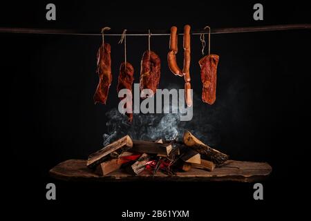 Smoked ham, bacon, pork neck and sausages in a smokehouse. Stock Photo
