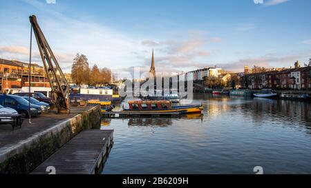 Bristol, England, UK - December 29, 2019: Evening sun shines on the spire of St Mary Redcliffe church and Bristol's historic docks. Stock Photo
