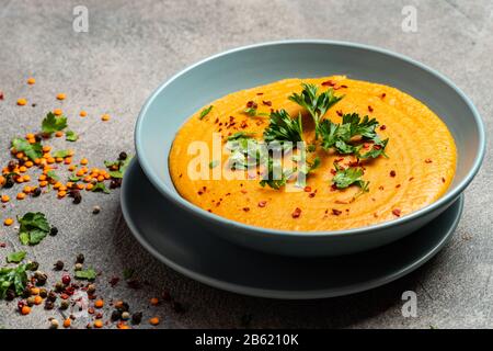 Traditional Indian soup lentils. Indian Dhal spicy curry in bowl, spices, herbs, rustic grey wooden background. Authentic Indian dish. Close-up. Stock Photo