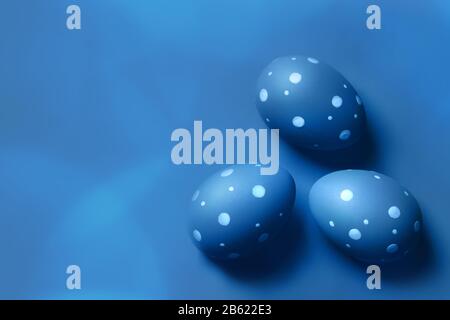 Colored decorated eggs on blue background. Easter concept, card with free copy space. Stock Photo