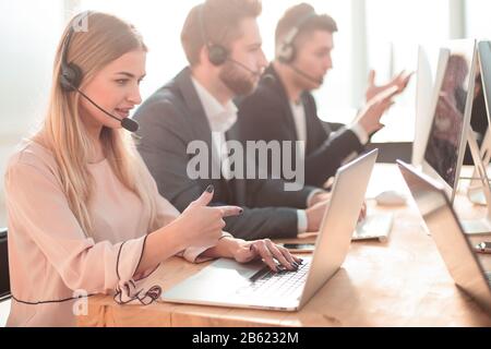 call center employees using computers to work with clients. Stock Photo