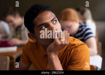 Side view of student thoughtful in class Stock Photo