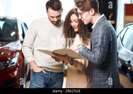 family choosing a car for travel, service. business. close up side view photo.man telling features of vehicle. close up side view photo. Stock Photo