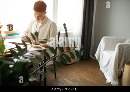 young man is enthusiastic about his work at home, student doing homework, preparing a project, business concept. close up photo Stock Photo