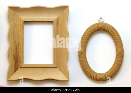 Two retro brown wooden frames hanging on white wall interior Stock Photo