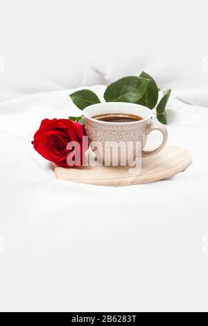 Black coffee with red rose on a white sheet Stock Photo