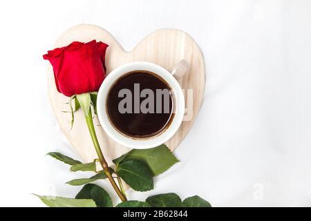 Black coffee with red rose on a white sheet Stock Photo