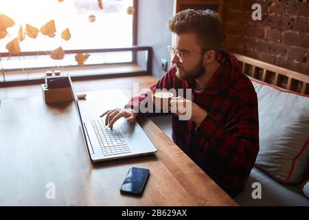 young freelancer concentrated on earning money, working with clients, customers online, close up side view photo. business Stock Photo