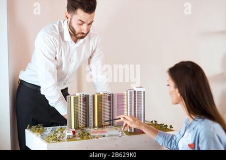 two ambitious achitects review the construction of building, close up photo, team discussing the projext, thinking how to improve, renovate new distri Stock Photo