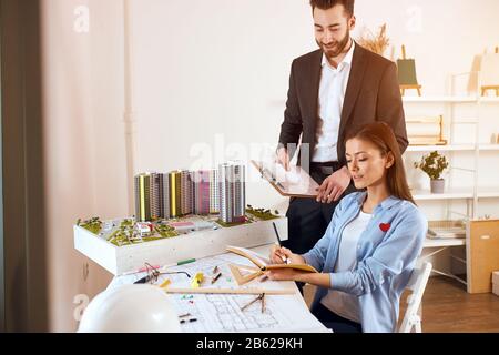 Teamwork concept Young business people discussing project at workplace, close up side view photo. job, profession, occupation , handsome bearded man h Stock Photo