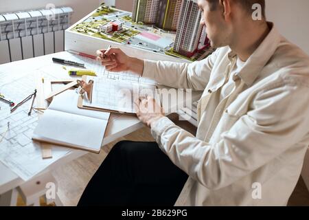 young talented professional achitect developing interior and working on the planning of buildings.close up side view photo. guy dreams to build palace Stock Photo