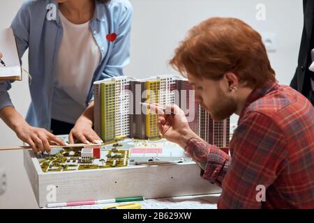 making accurate measurements, close up photo. pensive guy with a pen having a rest in the foreground of the photo,bearded serious man concentrated on Stock Photo