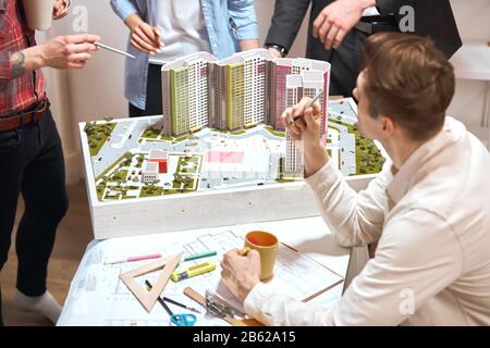 discussion about new neighbourhood, busy working atmosphere in the office, close up cropped photo. office workers standing around the model Stock Photo