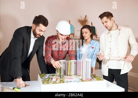 creating architect offers a successful plan to colleagues . close up photo. great idea for eco houses.architectural, construction and engineering indu Stock Photo