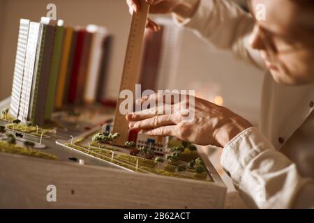 professional architect using engineering tools on model building, close up cropped photo Stock Photo
