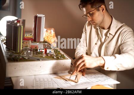 attractive architect developing measuring skills while sitting at workplace. close up photo, effort. Stock Photo