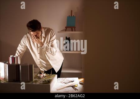 tired sleepy architect working at night, amn in white shirt wiping, touching his sick eyes, tiredness, busy working day. close up photo, problem . cop Stock Photo